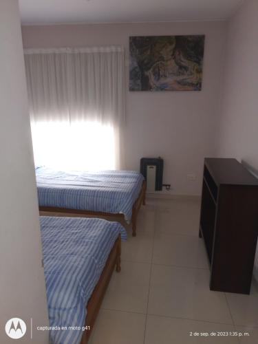 a small room with two beds and a window at Santa Rosa in Mendoza