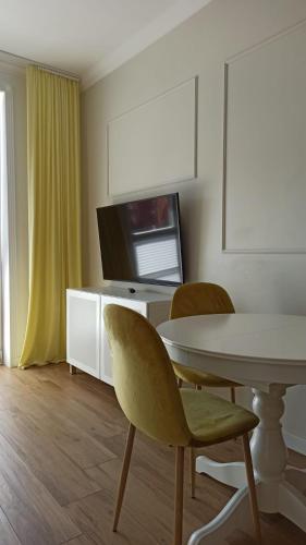 a dining room with a table and chairs and a tv at Apartament na Starówce in Elblag