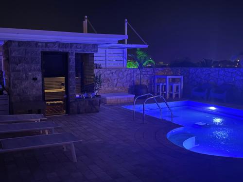 a night view of a swimming pool and a house at Nofesh Ba Alon 10 in Rosh Pinna