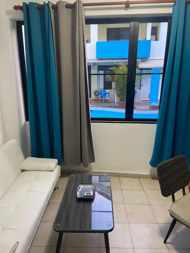 a living room with a couch and a table and a window at Full size 2 bedrooom 2 bath condo split in Sosúa