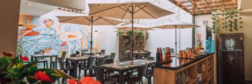 een restaurant met tafels en stoelen met parasols bij Cesar´s Hotel La Merced in Trujillo