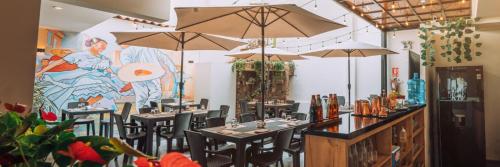 a restaurant with tables and chairs with umbrellas at Cesar´s Hotel La Merced in Trujillo
