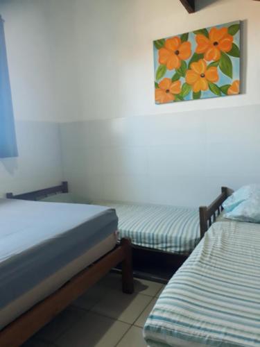 Zimmer mit 2 Betten und Wandgemälde in der Unterkunft Chalés sal da terra/Chalé in Caraguatatuba