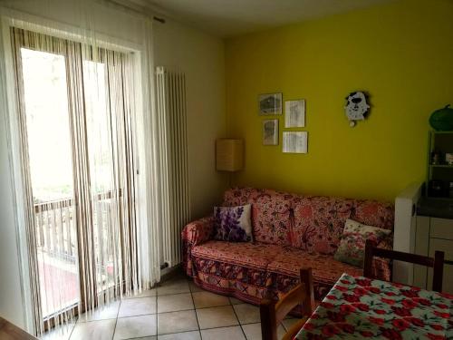 a living room with a couch and a large window at La Vache Qui Roule -CIR Charvensod 0037 in Aosta