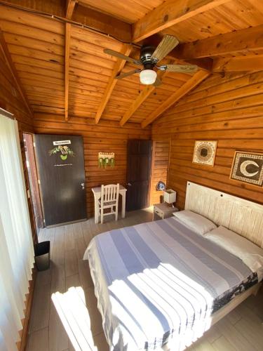 a bedroom with a bed in a wooden cabin at Cabañas Tr'eje in Valle de Bravo