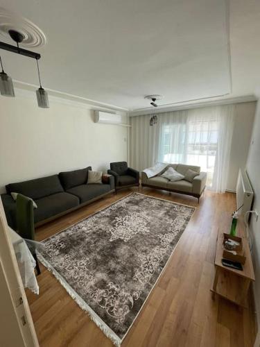 sala de estar con sofá y alfombra en Çift klimalı, 110m2, 3+1, metro 5dk, 1000mbps inte, en Karşıyaka
