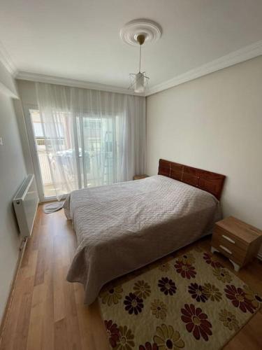 1 dormitorio con 1 cama con alfombra y ventana en Çift klimalı, 110m2, 3+1, metro 5dk, 1000mbps inte, en Karşıyaka