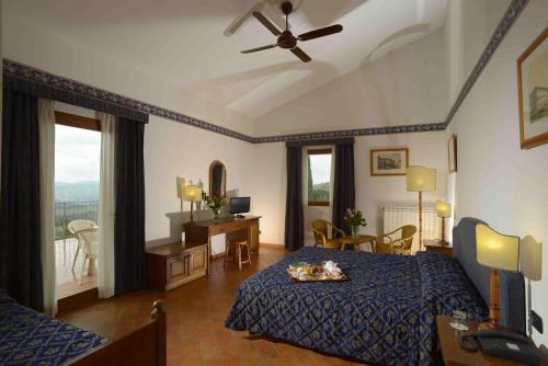 una camera con letto e ventilatore a soffitto di Fattoria Degli Usignoli a San Donato in Fronzano