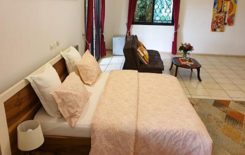 a bedroom with a large bed with pillows at Villa Mia in Abidjan