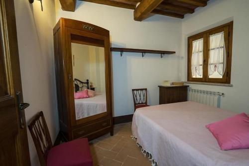 sypialnia z 2 łóżkami i dużym lustrem w obiekcie Appartamento con vista panoramica w mieście Pienza