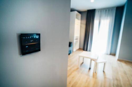 a living room with a table and a tv on a wall at Arevalos Hotel in Cuenca