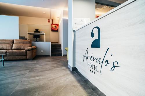 una pared con un cartel en la sala de estar en Arevalos Hotel en Cuenca