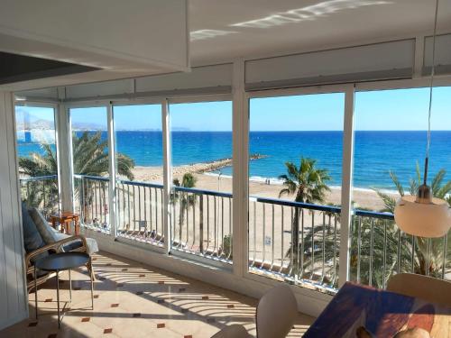 een kamer met een balkon met uitzicht op het strand bij FirstLine BeachView in El Campello