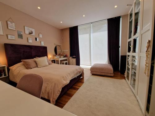 a bedroom with a large bed and a large window at Azalea Dreams by Santa Marija Estate in Mellieħa