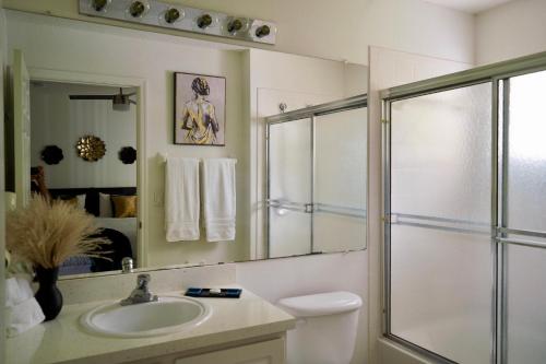 a bathroom with a toilet and a sink and a shower at Enchanting Escape 3 Bedroom Minutes from Disney! in Kissimmee