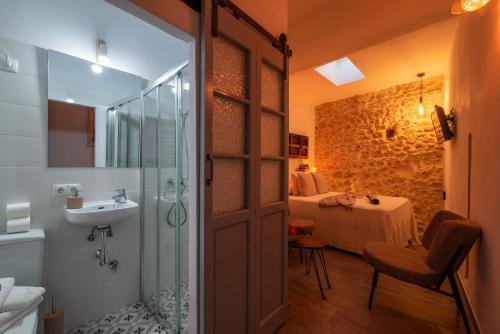 uma casa de banho com um chuveiro, um lavatório e uma cama em Alojamientos Plaza de España em Medina-Sidonia