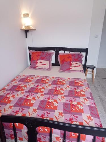 ein Schlafzimmer mit einem Bett mit einer bunten Decke in der Unterkunft Appartement in Troyes