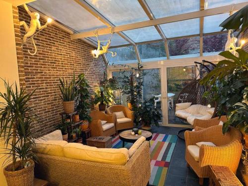 a living room with a conservatory with couches and plants at Large Quiet Whole House near Historic Gent Centre in Ghent