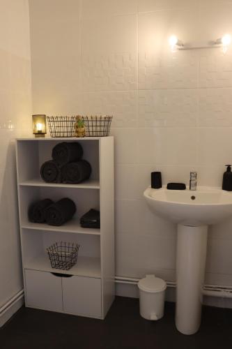 een badkamer met een wastafel, een toilet en een witte wastafel bij Appartement in Troyes