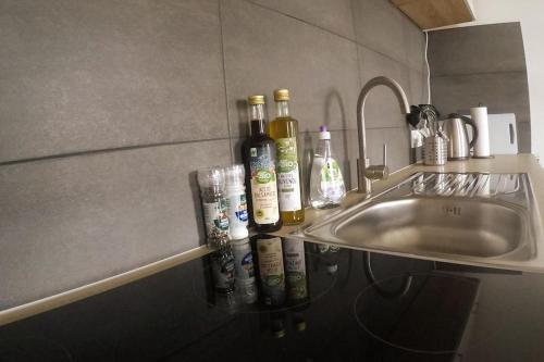 a counter with bottles of wine and glasses next to a sink at Studio-Apartementwohnung in Kassel
