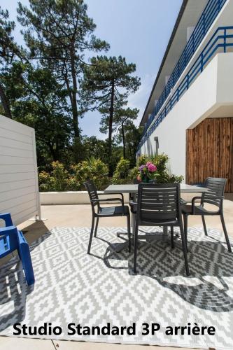 a patio with a table and chairs on a rug at Hotel Mercedes in Hossegor