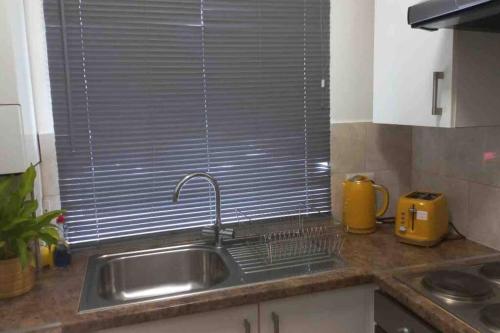 a kitchen counter with a sink and a window at Edgware Road Large Ground Floor Studio in London