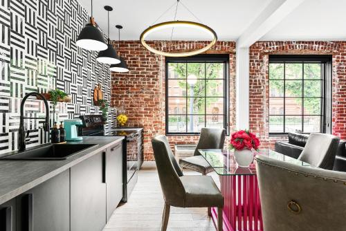 a kitchen with a brick wall and a table with chairs at The Acoma House in Denver