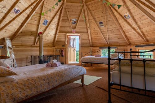 a bedroom with two beds in a wooden cabin at Exmoor Lodge (Oak Tree Lane) in Okehampton