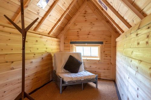 a chair in the corner of a log cabin at Exmoor Eco-Pod - Oak Tree Lane in Okehampton