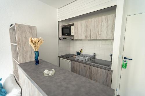 a kitchen with a vase of flowers on a counter at Hotel Mercedes in Hossegor
