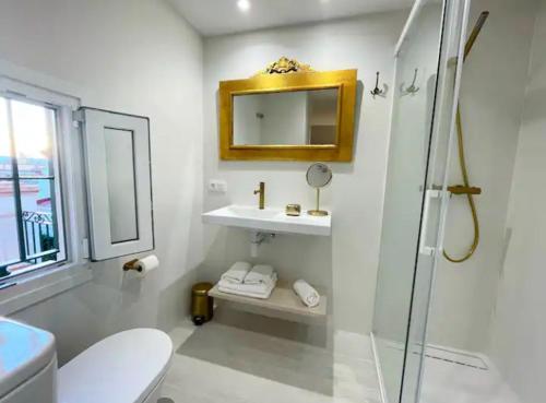 a bathroom with a toilet and a sink and a mirror at Eva Recommends San Gil in Seville