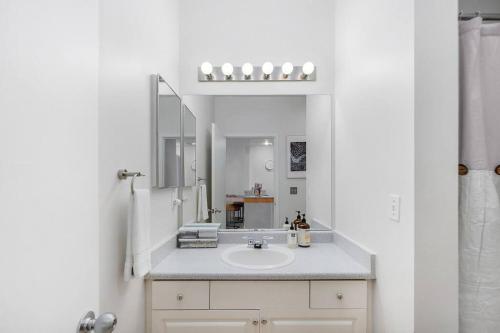 a white bathroom with a sink and a mirror at Needle's Edge - 99 Walkscore! in Seattle