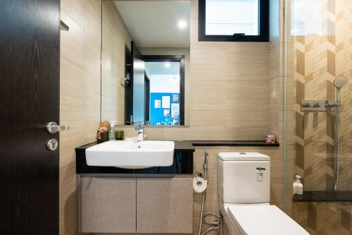 uma casa de banho com um lavatório, um WC e um espelho. em Feliz en Vista New Duplex 2br Highclass em Ho Chi Minh