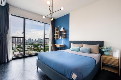 ein Schlafzimmer mit einem blauen Bett und einem großen Fenster in der Unterkunft Feliz en Vista New Duplex 2br Highclass in Ho-Chi-Minh-Stadt