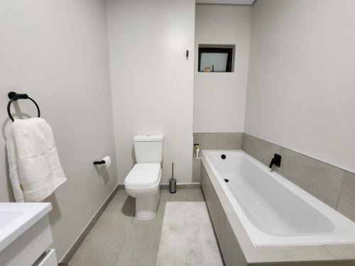 biała łazienka z wanną i toaletą w obiekcie 97B Flex 2 on Murray, Waverly w mieście Johannesburg