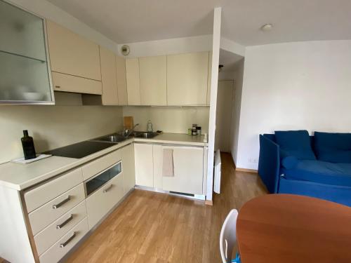 a kitchen with white cabinets and a blue couch at Pretty flat 2mn from beach in Nice