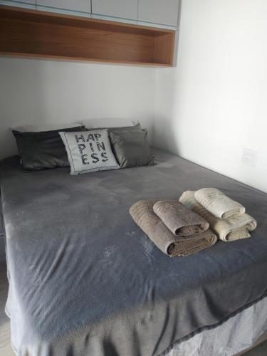 een bed met twee dekens en kussens erop bij Studio Próximo ao metrô Butantã in Sao Paulo