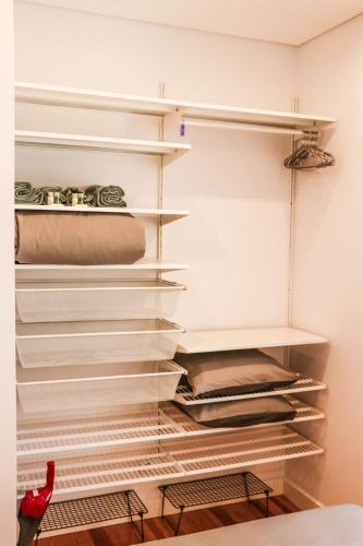 a walk in closet with white shelves at Golden Place - Cacilhas in Almada