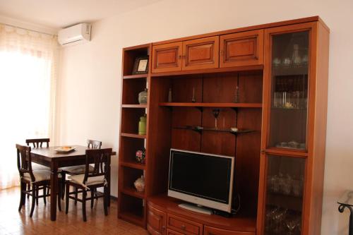 a living room with a television and a dining room table at Roma a un passo e il mare in casa in Marina di Cerveteri