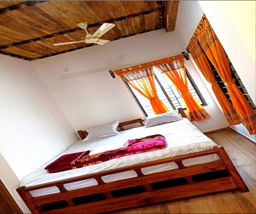 1 dormitorio con 1 cama en una habitación con ventanas en Khoai Village Resort en Shānti Niketan