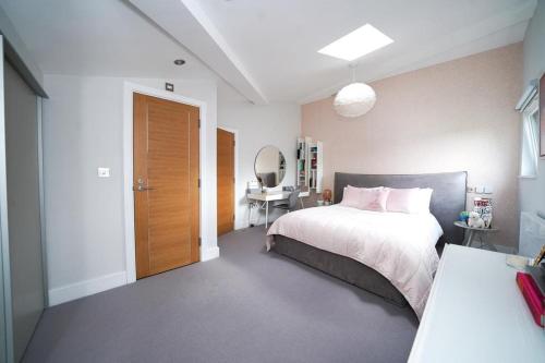 Schlafzimmer mit einem Bett und einem Schreibtisch mit einem Spiegel in der Unterkunft Town House in Leamington Spa in Leamington Spa