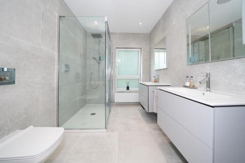 ein Bad mit einer Dusche, einem Waschbecken und einem WC in der Unterkunft Town House in Leamington Spa in Leamington Spa