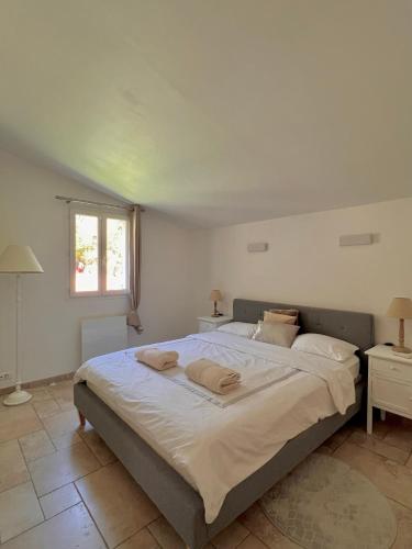une chambre avec un grand lit avec deux serviettes dessus dans l'établissement Le Mas Provençal Valbonne, à Valbonne