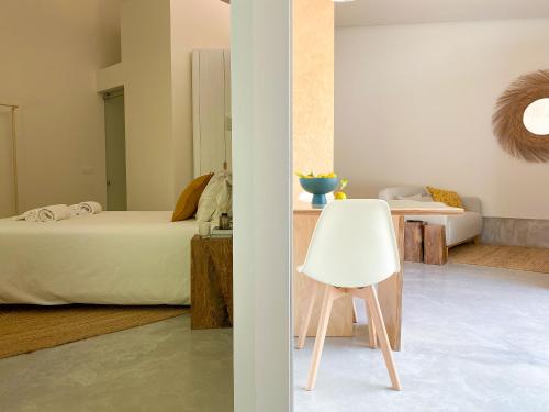 a bedroom with a bed and a white chair at Casa do Rio in Leiria