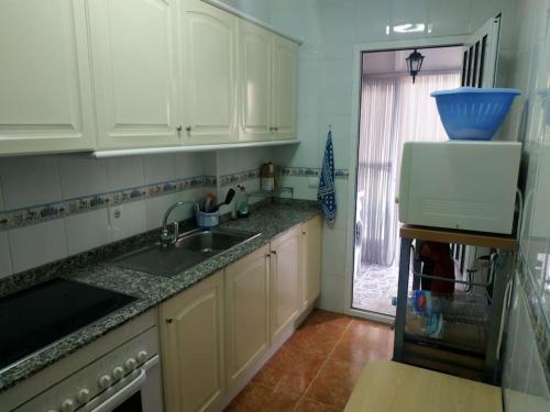 a kitchen with white cabinets and a sink and a window at CASA ALMA Playa Paraiso Estupenda vivienda cerca de la Playa in Cartagena