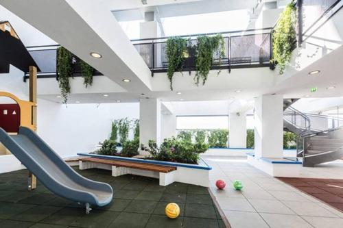 un vestíbulo con una escalera con plantas en el techo en EuroSky Prestige Apartment ROMA EUR en Roma