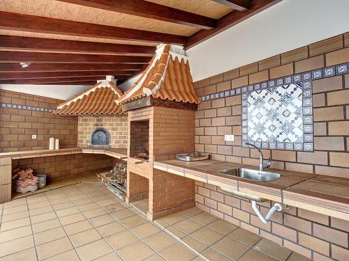 uma cozinha com uma casa de brincar com um lavatório em Vinhaticos Villa by Atlantic Holiday em Porto Moniz