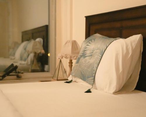 a pillow sitting on a bed next to a lamp at Raqeem Hotel in Wadi Musa