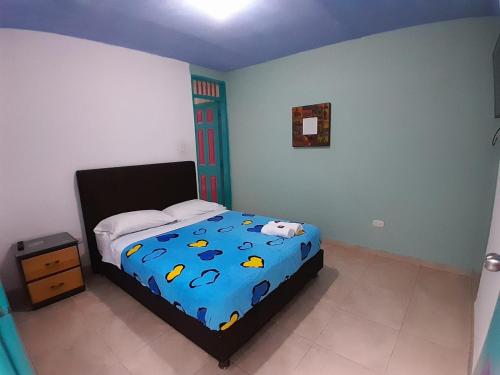a bedroom with a bed with a blue comforter at Hostal Johnnier in Salento