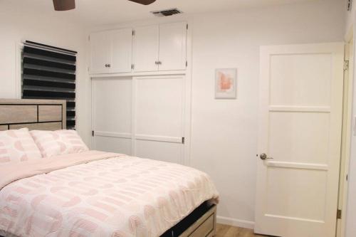 ein weißes Schlafzimmer mit einem Bett und einem Schrank in der Unterkunft Newly Furnished Pool House in Los Angeles